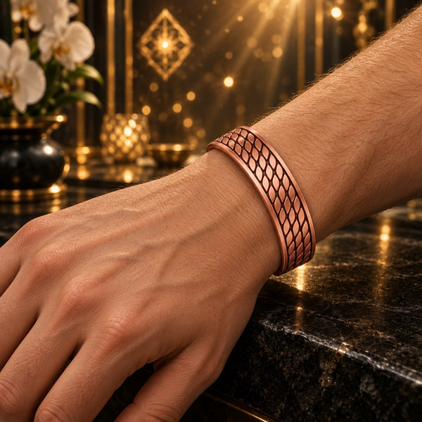 Clarity Code copper bracelet with a staggered leaf pattern, worn on a hand model’s wrist in warm golden light.